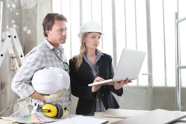 istock man and woman architect interior designer and foreman worker together with computer and decorative materials discussing the project for interior decoration in the inside the construction building site 1217768686