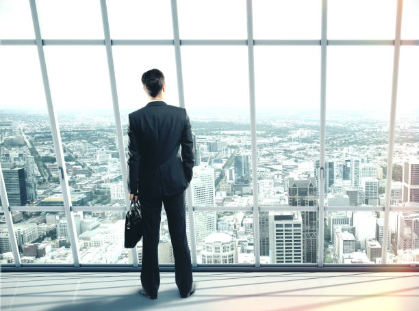 istock Businessman with case standing in office 1217769393