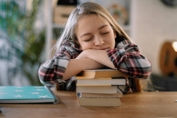 istock Tired little girl doing homework at home. 1217769432