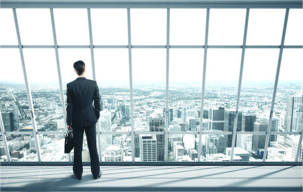istock Businessman with case standing in office 1217769616