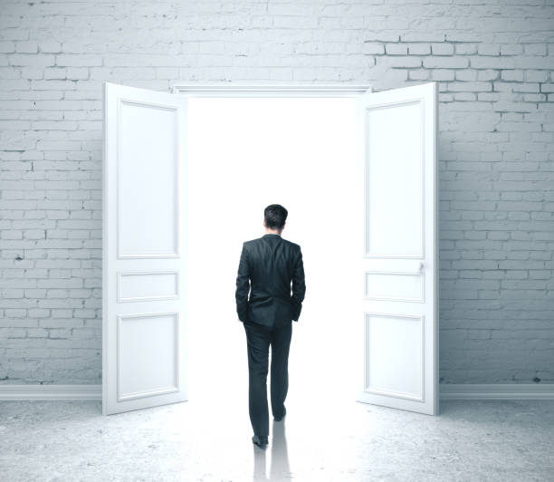 istock Businessman walking in open door 1217769825