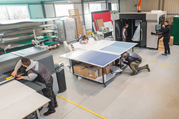 istock Large group of technicians works in printing printshop press hall 1217769867