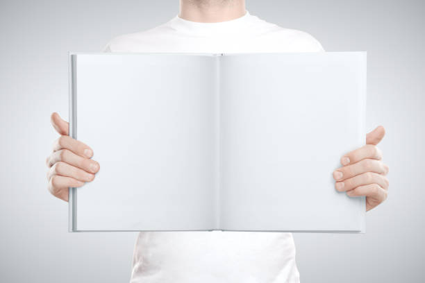 istock Man holding blank book in hand. 1217770024