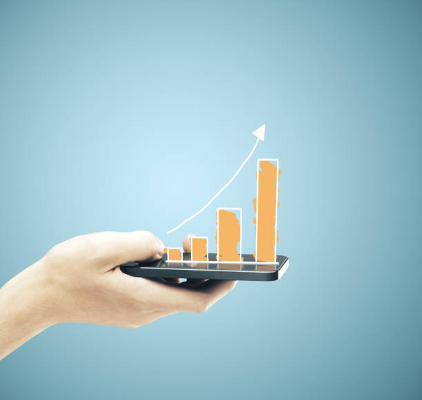 istock Hand hodling smartphone with business chart 1217770074