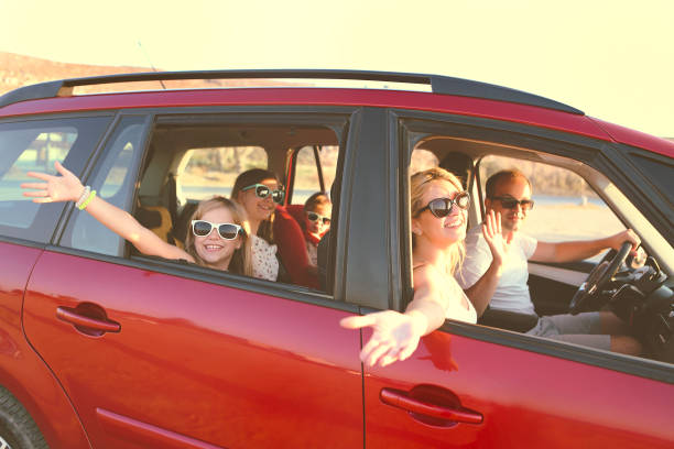 glücklich lächelnde familie mit töchtern im auto mit meereshintergrund - autoreise fotos stock-fotos und bilder