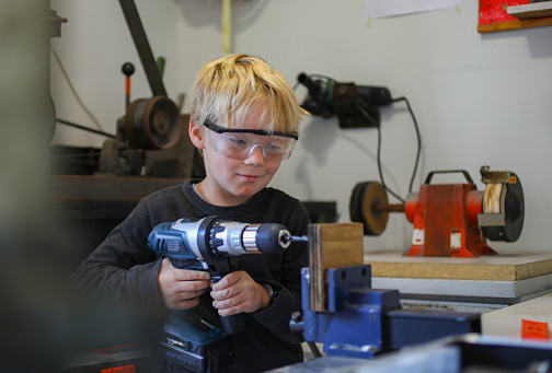 A young boy working with carpentry tools