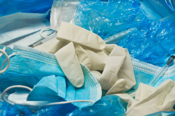 Medical trash. Coronavirus protection equipment in medical waste bin. Used face masks and sterile gloves. Doctor uniform for patient treatment in hospital. Prevention the spread of COVID-19. basura médica. equipo de protección contra coronavirus en un contenedor de residuos médicos. máscaras faciales usadas y guantes estériles. uniforme médico para el tratamiento del paciente en el hospital. prevención de la propagación de covid-19.