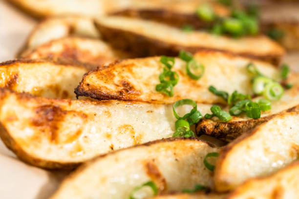 istock Freshly baked potato wedges with spices on a white serving tray. 1217779092