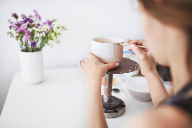 istock Beautiful girl sculpts a cup from clay pot. 1217779253