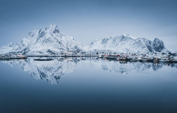 scenic panorama of snow covered mountain range reflected in cold waters of arctic sea - arctic sea imagens e fotografias de stock