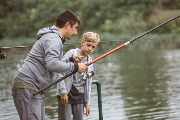 istock Side view of dad explaining to son how to fish 1217784524