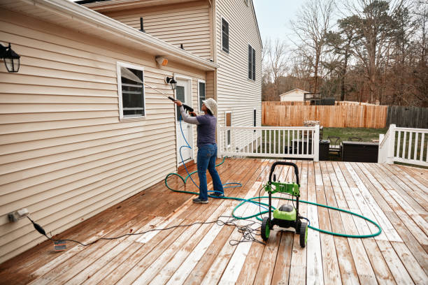 Woman Cleaning Wooden Terrace With A High Water Pressure Cleaner Latin woman using high water pressure cleaner to clean wall. house washing stock pictures, royalty-free photos & images