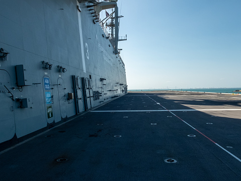 Military helicopters Blackhawk take off from an aircraft carrier at sunrise in the endless sea.