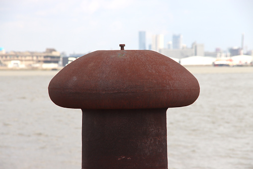 Rust-colored bollard for mooring ships in the port of Rotterdam  in the netherlands
