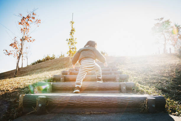 Baby going up stairs Asian baby girl walking up stairs in the park. first steps stock pictures, royalty-free photos & images