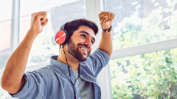 istock young man freelancer in headphones dancing at home 1217791797