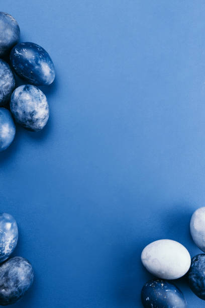istock Beautiful group ombre blue Easter eggs with quail eggs and feathers on a blue background. Easter concept. Border eggs. Copy space for text. 1217792227