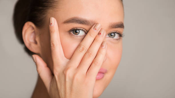 istock Young woman looking at camera through fingers 1217792473
