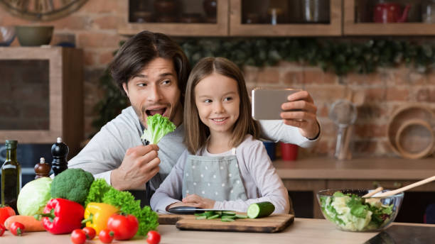 istock Joyful Dad Taking Selfie On Smartphone With Little Daughter In Kitchen 1217793977