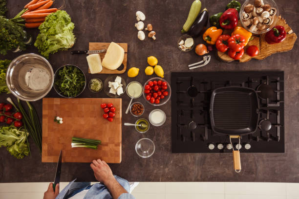 istock Man about to chop green onion on a cutting board 1217796374
