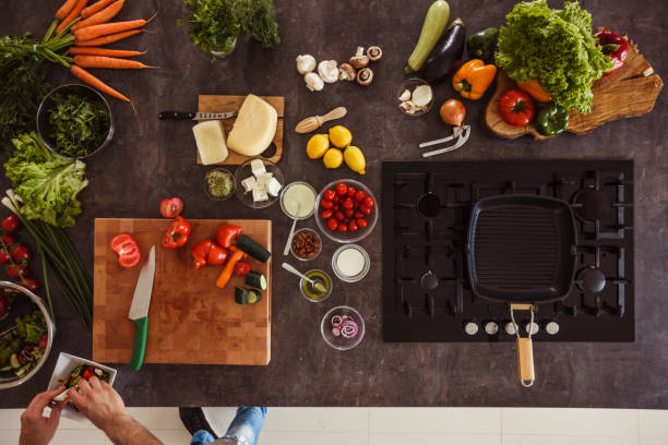 istock Man serving up salad he prepared in a bowl 1217796389
