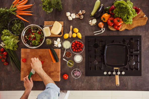 istock Man chopping cheery tomatoes for a salad he is preparing 1217796396