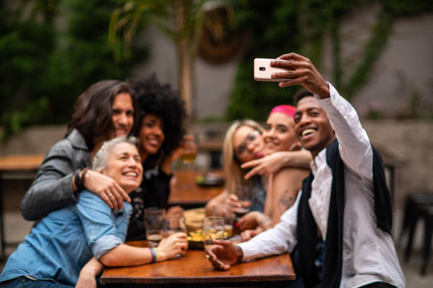 istock Multi-ethnic smiling and taking selfie at outdoor pub 1217799071