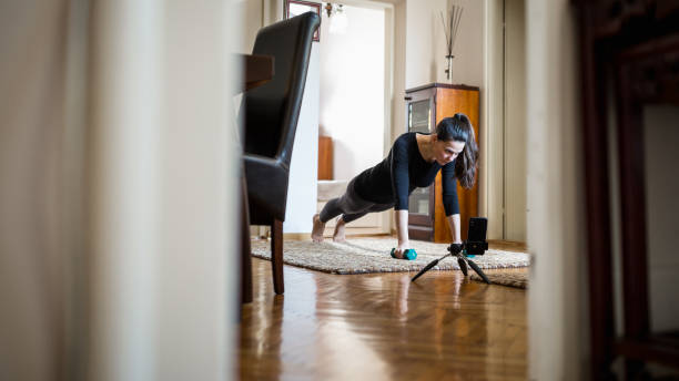 istock Woman exercising at home with online coach support 1217799435