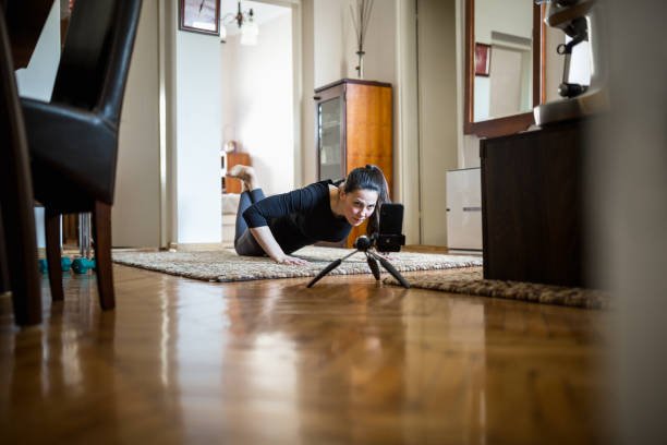 istock Woman exercising at home with online coach support 1217799554
