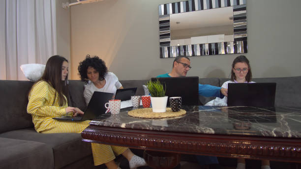 istock Working from home.in a relaxing environment. distance work and education, family sitting on laptops in pajamas and keep social distancing as prevention from corona covid19 virus spread, a world pandemic 1217799583