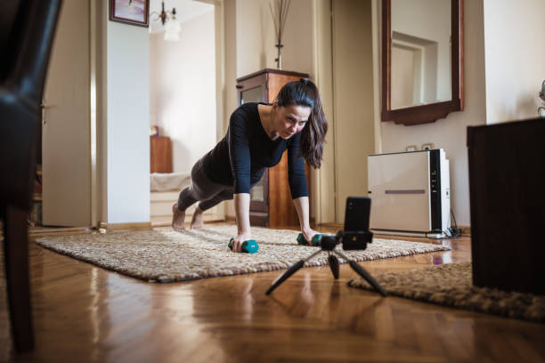 istock Woman exercising at home with online coach support 1217799656