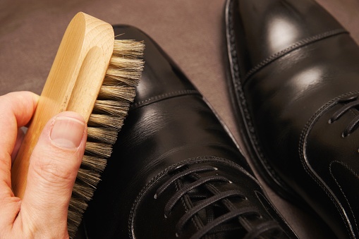 Leather shoes during brushing. Moving the brush little by little.