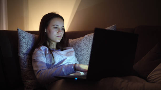istock Happy smiling female teenager e-learning sitting on sofa at home during corona quarantine isolation 1217799961