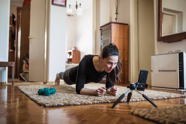 istock Woman exercising at home with online coach support 1217804107