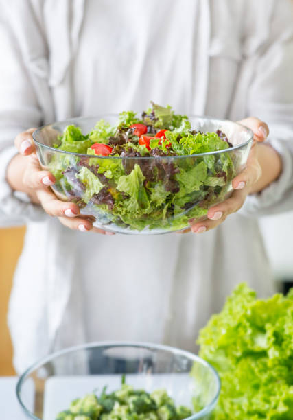 istock Unrecognizable woman preparing a green mixed salad in the kitchen 1217804117