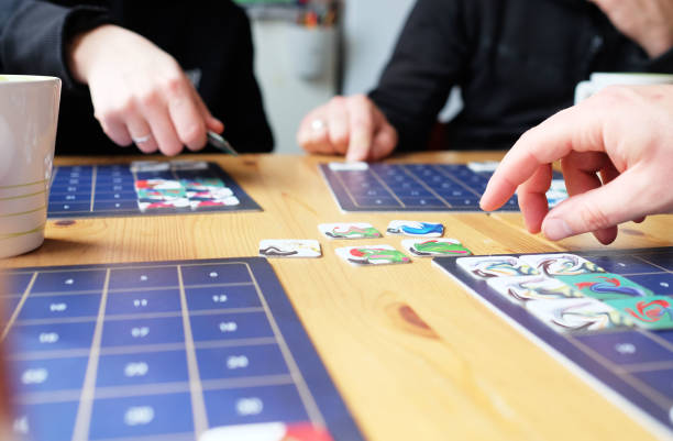 istock Only hends visible. Friends sitting playing board game at wooden table. Concept spending time at home. Selective focus 1217804140