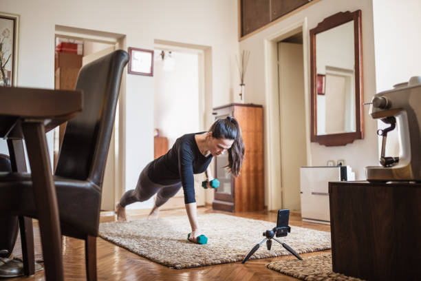 istock Woman exercising at home with online coach support 1217804154