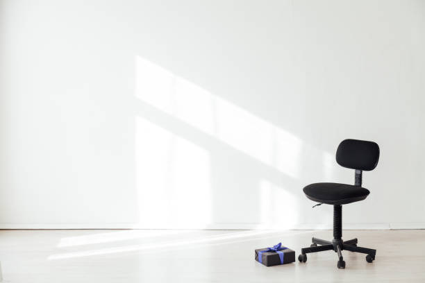 istock black office chair with a gift in an empty white office 1217804983