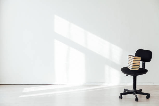 istock black office chair with a gift in an empty white office 1217805016