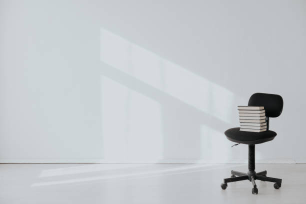 istock black office chair with a gift in an empty white office 1217805033