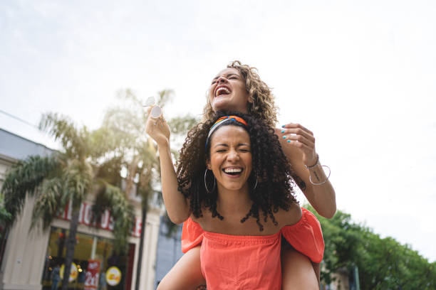 istock Playful young Hispanic women piggyback riding 1217805969