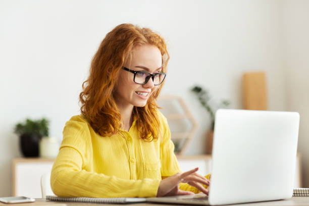 istock Young woman working on laptop at home office 1217808032