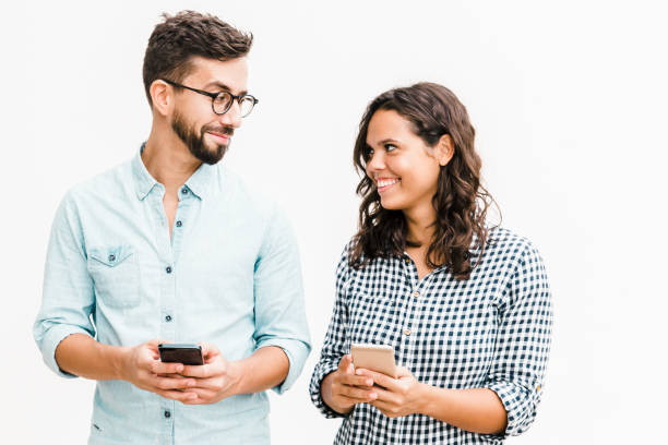 istock Cheerful couple using cellphones 1217809540