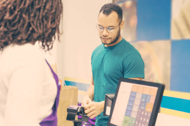 istock Focused young man paying bill in store 1217809611