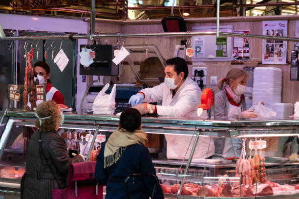 Butcher and her customer at the Central Market during the Covid 19 coronavirus pandemic in Valencia, Spain stock photo