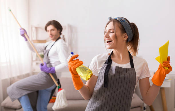 istock Playful Couple Having Fun While Cleaning Flat Together 1217811905