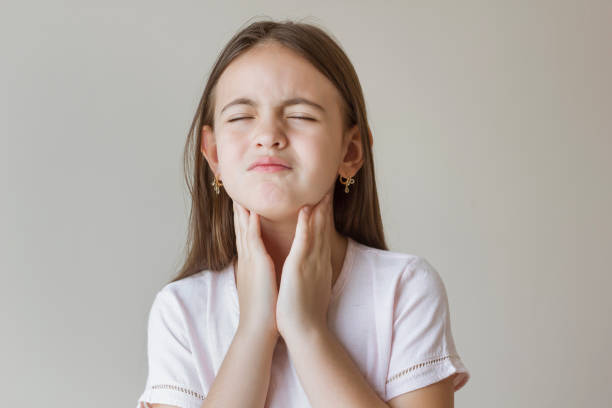 bambina con mal di gola che le tocca il collo. mal di gola malato. bambina che ha dolore alla gola - groping foto e immagini stock