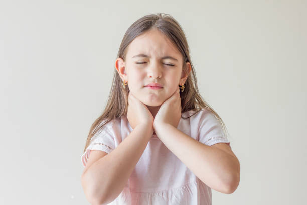 Little girl with sore throat touching her neck.Sore throat sick.Little girl having pain in her throat. Little girl with sore throat touching her neck.Sore throat sick.Little girl having pain in her throat. cerebrum photos stock pictures, royalty-free photos & images