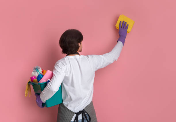 Neat Man Cleaning Wall With Rag And Holding Bucket With Detergents