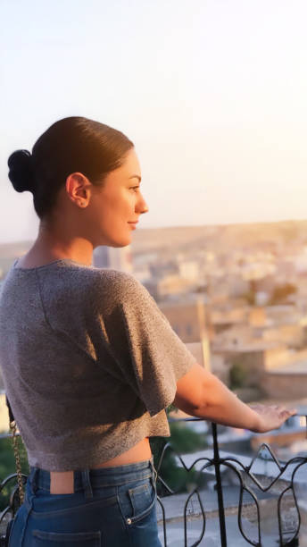 istock woman looking out from the balcony 1217812934